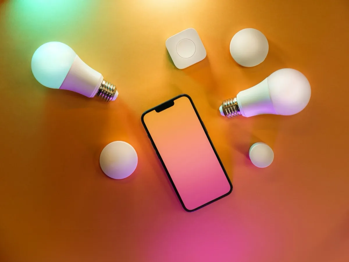 Smart bulbs and phone showing home automation control